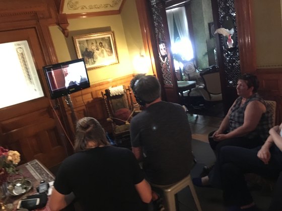 Crew working around a monitor in a furnished room